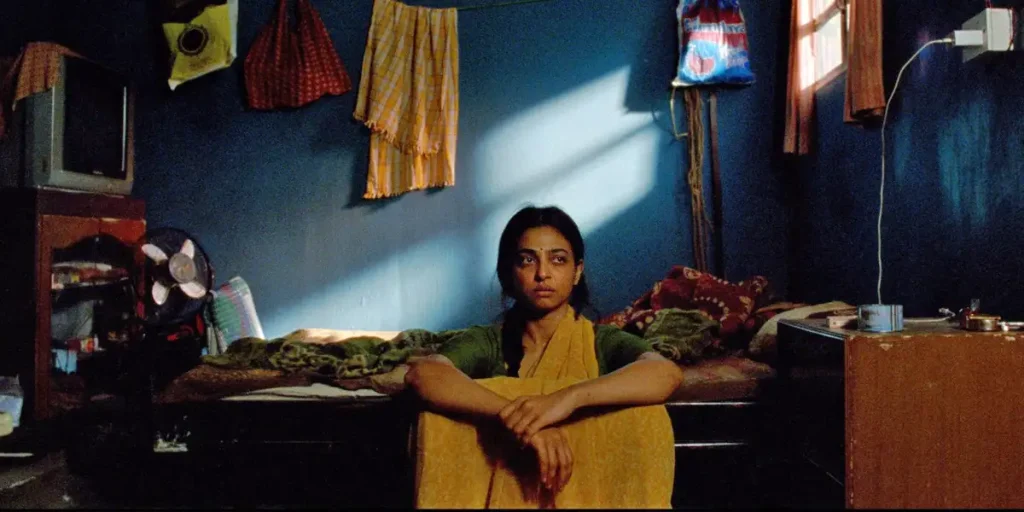 Radhika Apte, whom we interview in this article, sits on the floor in her messy house looking unhappy in a still from SIster Midnight