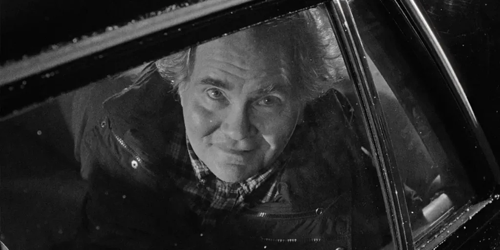 Erik Bjarnar looks at the sky from a car window in a black and white still from the movie Stationed at Home