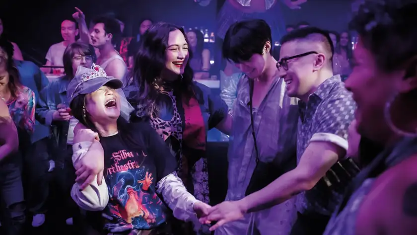 Youn Yuh-jung, Lily Gladstone, Han Gi-chan and Bowen Yang dance in a still from the 2025 movie The Wedding Banquet