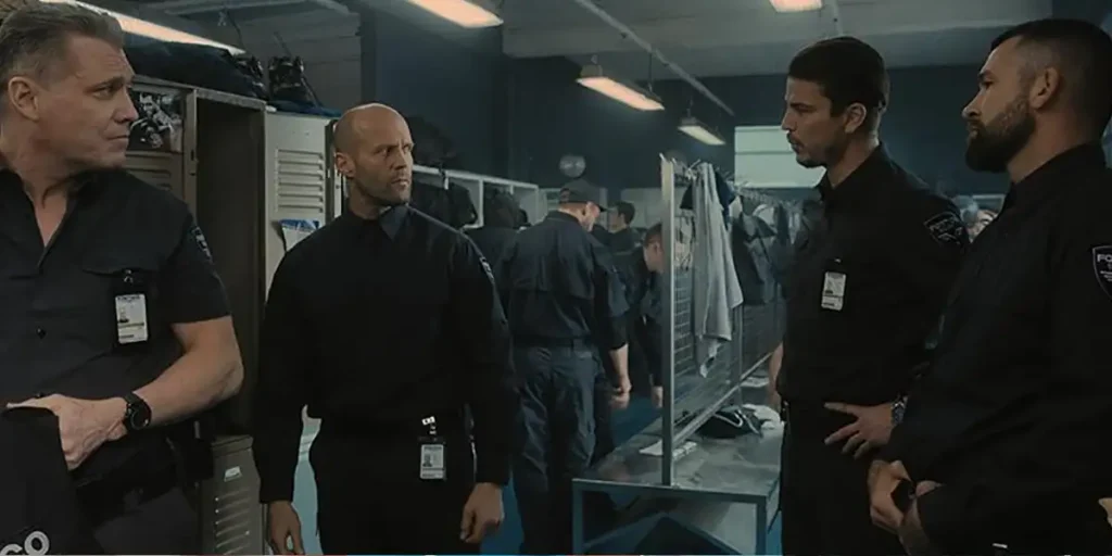 Four men stand in a locker room in the movie Wrath of Man