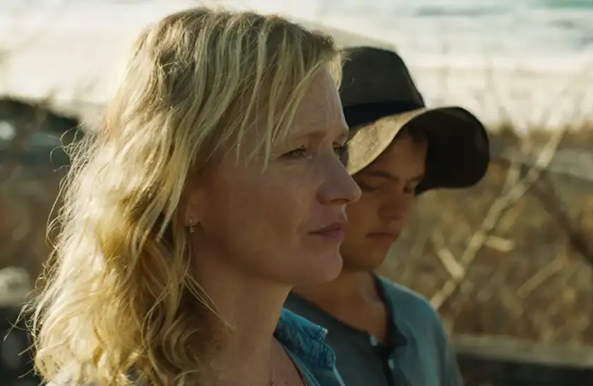 A woman and a boy stand by the beach in a still from the film Caravan (Karavan), one of the 20 movies to watch at the 2025 Cannes film festival according to Loud and Clear Reviews