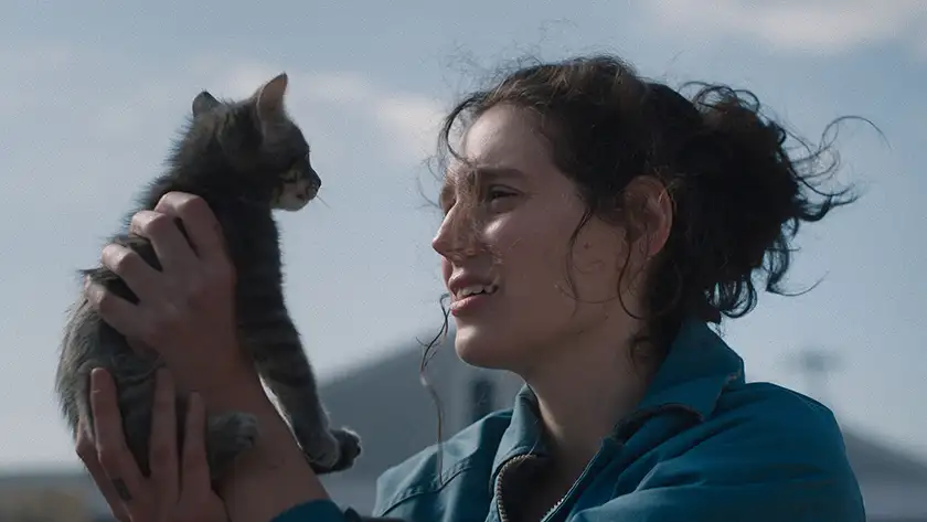 A woman holds a cat in a still from the film Sorry Baby, one of the 20 movies to watch at the 2025 Cannes film festival according to Loud and Clear Reviews