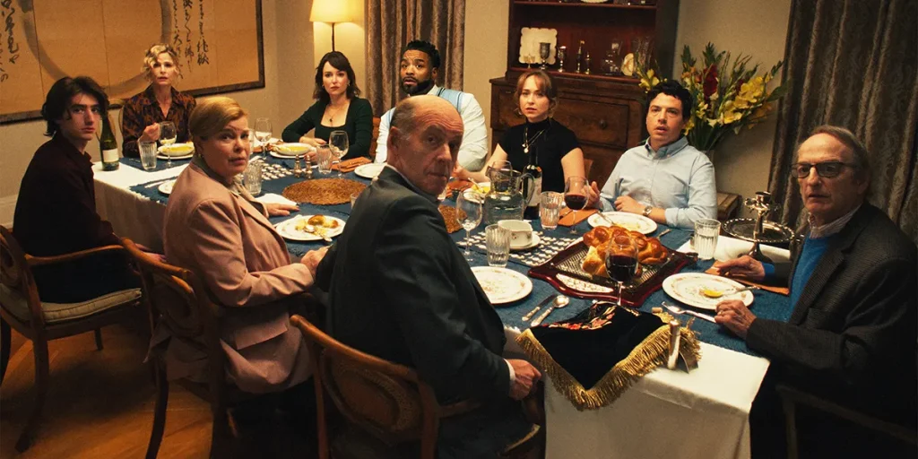 A family sits around the dinner table and poses for a picture in the 2025 film Bad Shabbos