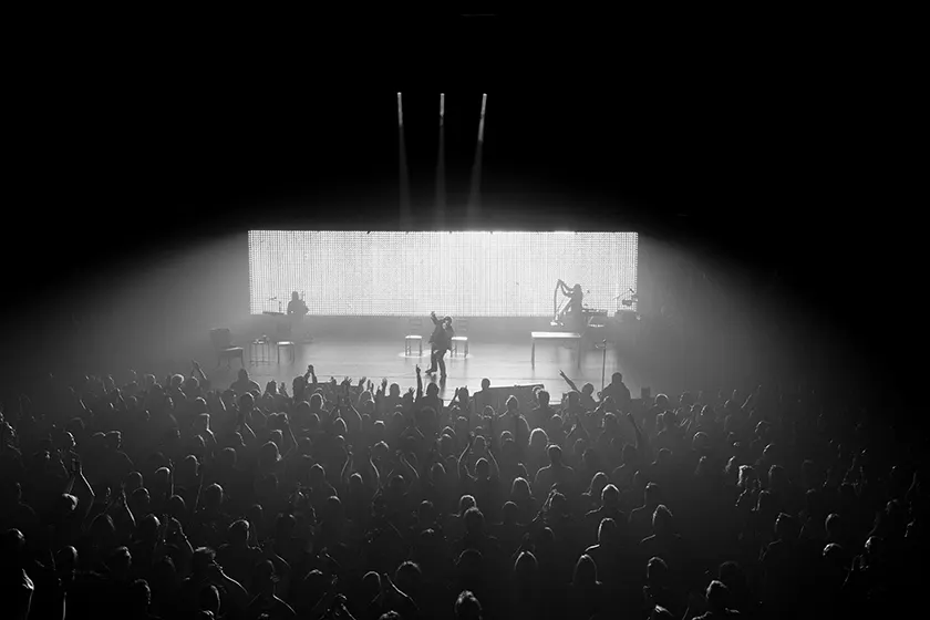 Bono sings to a crowd in a black and white still from Bono: Stories of Surrender