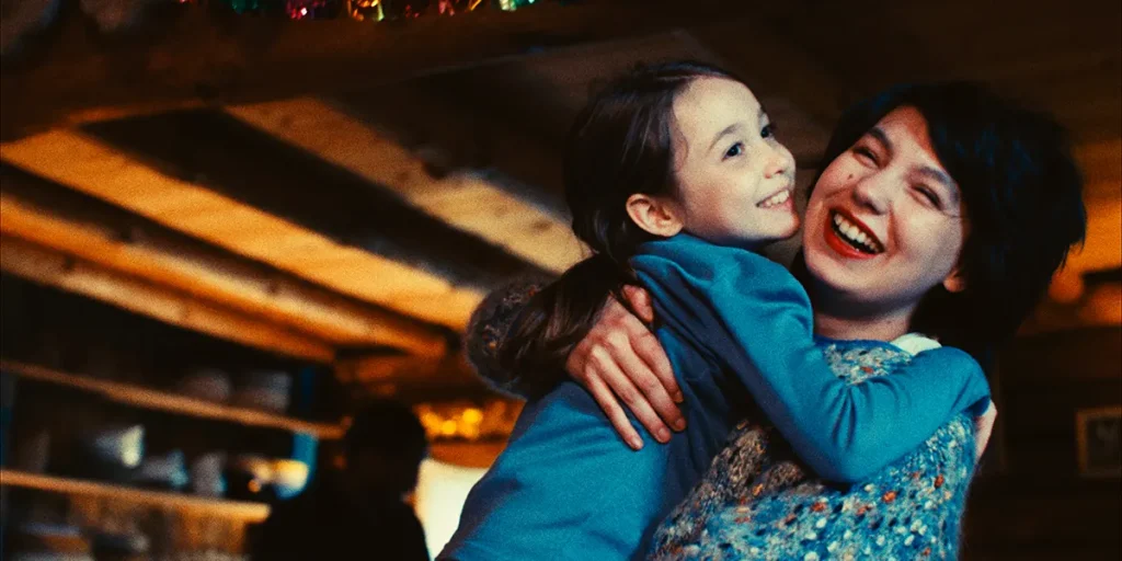 A little girl huge her mother in a still from the 2025 film Tell Her I Love Her (Dites-Lui Que Je L'Aime)