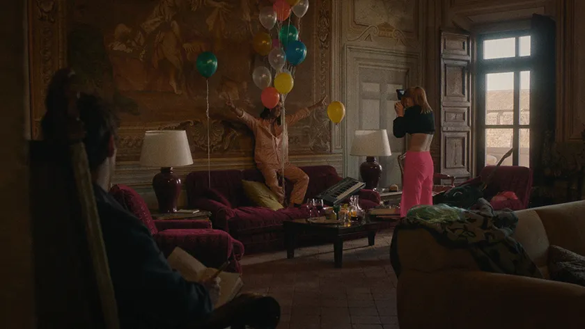 Three characters take photos of each other in a still from the film Electra