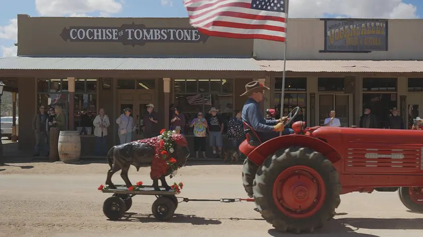 A man drives a tractor with an American Flag on it in a still from the film Henry Fonda for President
