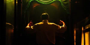 A conductor stands in front of an orchestra, seen from behind, in a still from the film Resurrection (Kuang Ye Shi Dai), from director Bi Gan