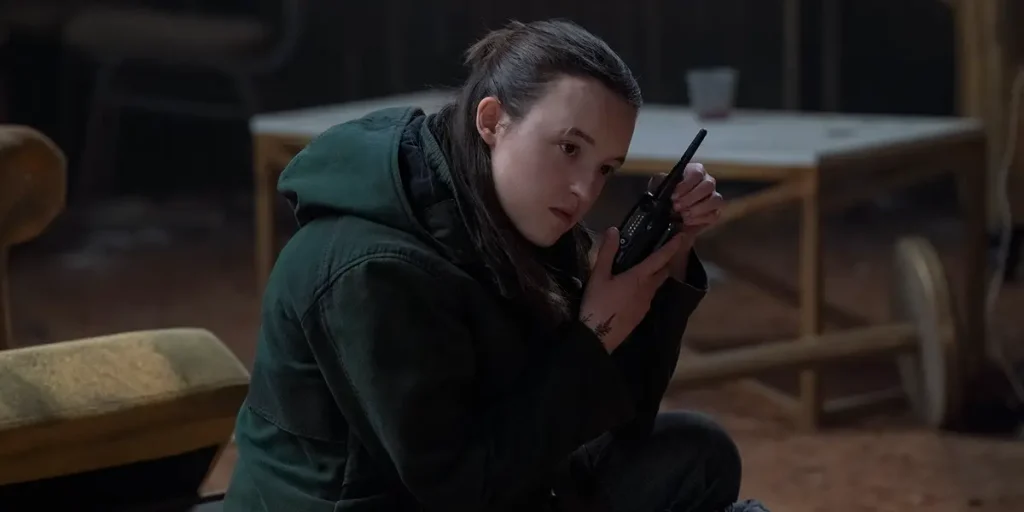Bella Ramsey listens to a pager in the Season 2 Finale of The Last Of Us