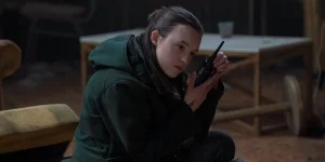 Bella Ramsey listens to a pager in the Season 2 Finale of The Last Of Us
