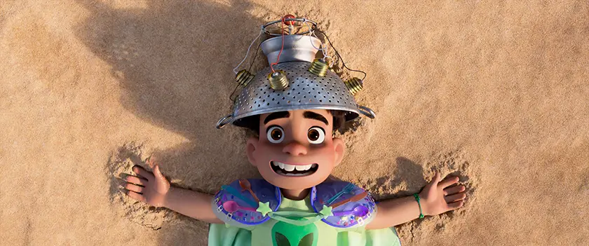 Elio (voice of Yonas Kibreab) is on the beach in Disney and Pixar’s “Elio”
