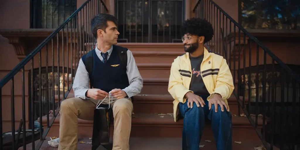Tristan Turner and and Anthony Oberbeck sit on the stairs in a still from the film The Travel Companion