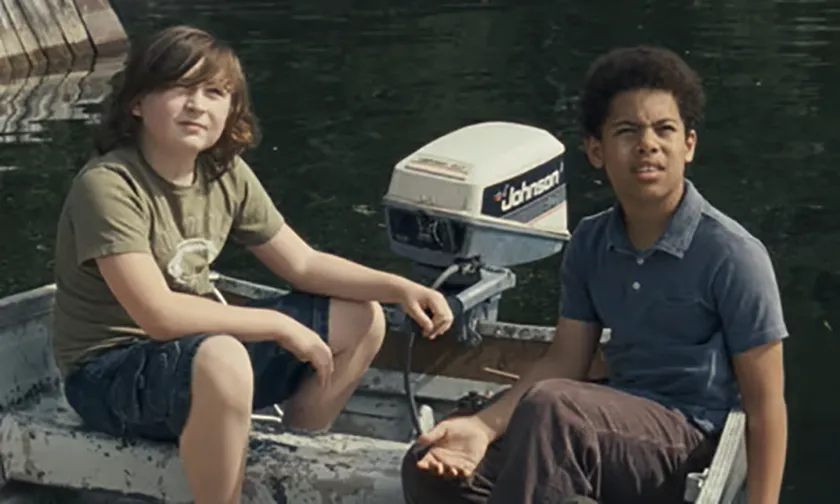 Two boys sit on a boat in a still from Allen Sunshine