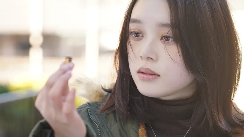 Akari Takaishi picks up a bullet shell in the 2025 movie Ghost Killer