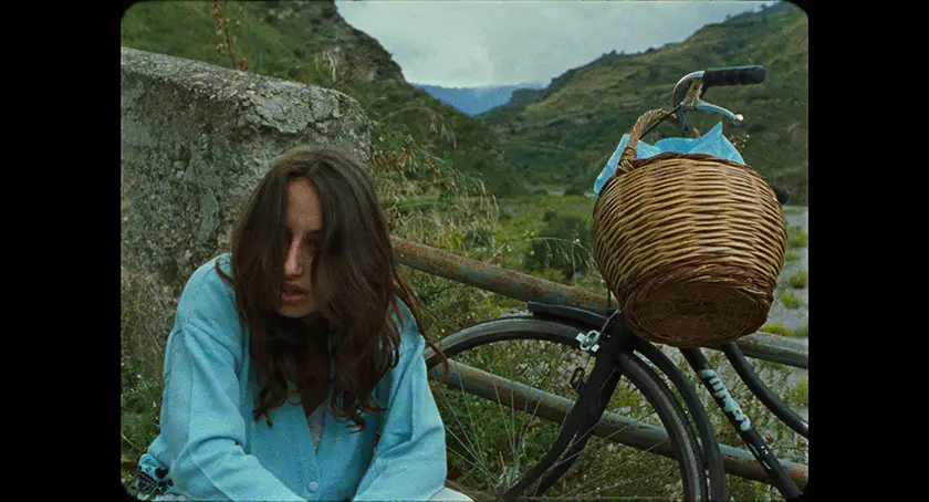 Gabriella Maiollo sits on the grass next to her bike in the film Il Dono