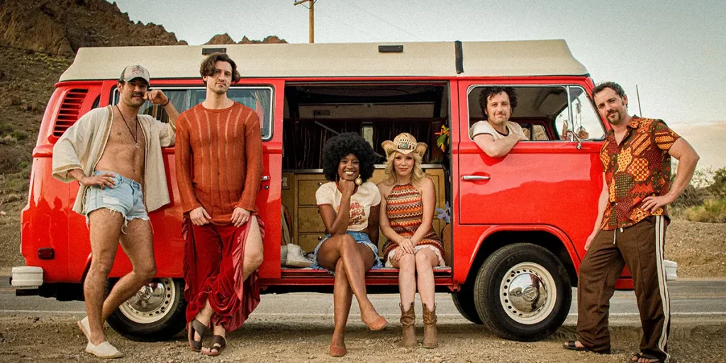 Two women and three men stand by a red truck in the film Brute 1976