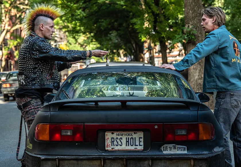 Russ (Matt Smith, left) hands over the keys to Hank (Austin Butler, right) in the movie Caught Stealing.