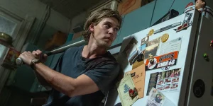 Hank (Austin Butler) stands with a baseball bat in the movie Caught Stealing