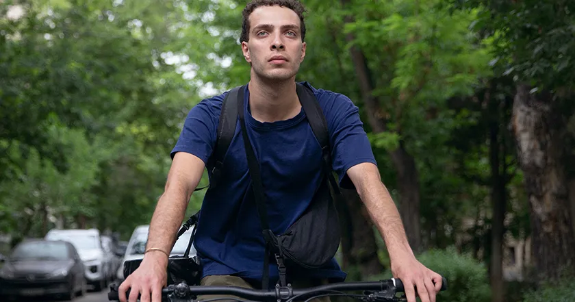 a boy is on a bike in a still from the 2005 film Daroon-E-Amir, one of the 25 Movies to Watch at the 2025 Venice Film Festival according to Loud and Clear Reviews