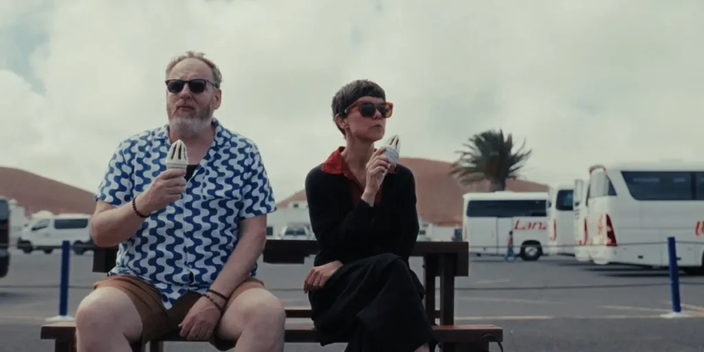 A man and a woman eat ice cream on a bench in a still from the film Signs of Life