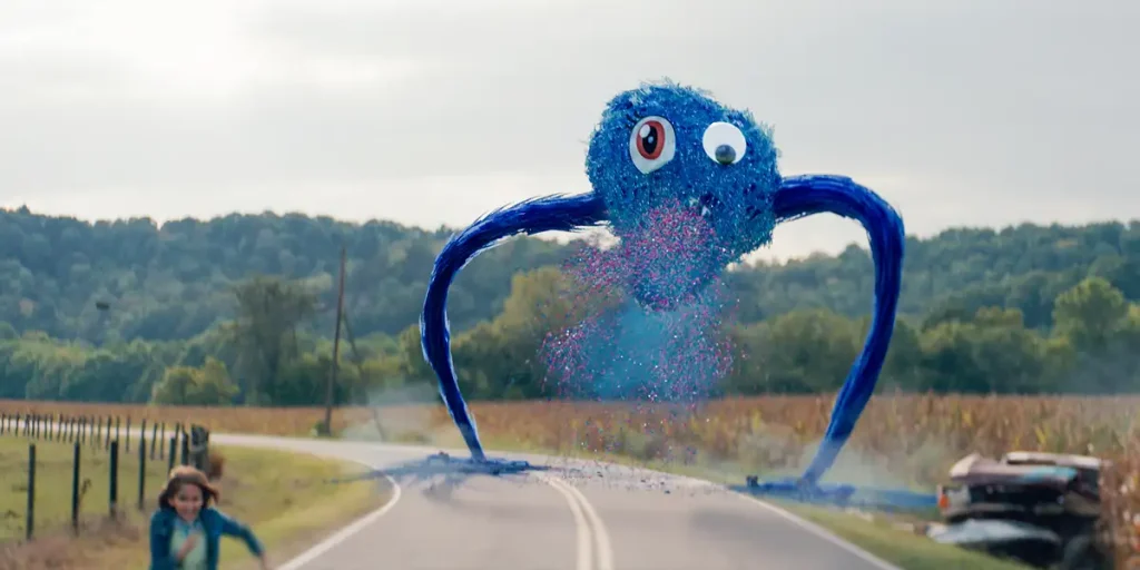 A blue monster chases a little girl in a still from the movie Sketch