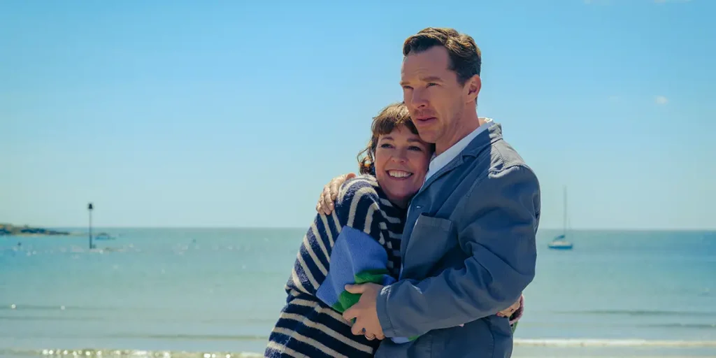 Olivia Colman and Benedict Cumberbatch hug by the beach in THE ROSES