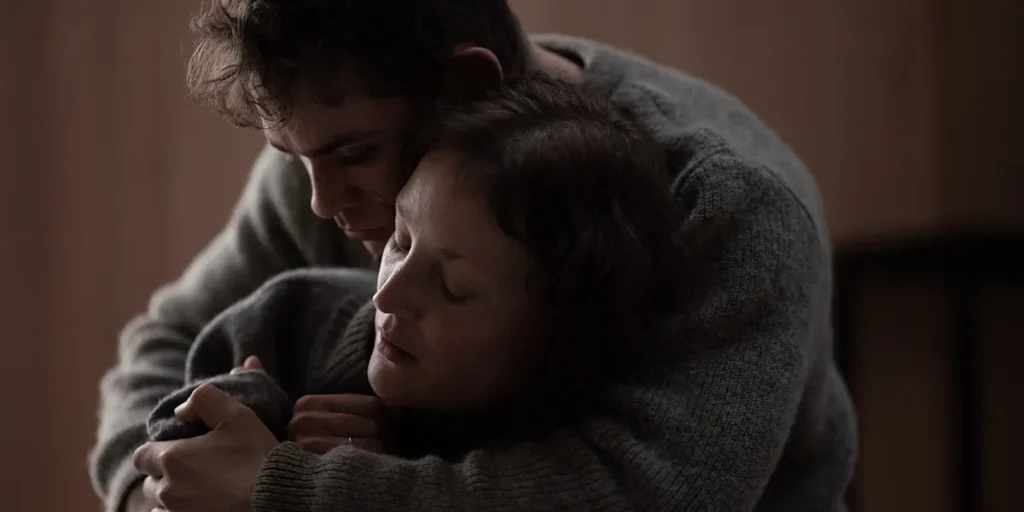 Dacre Montgomery and Vicky Krieps hug in the film Went Up the Hill