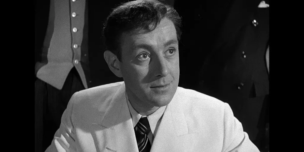 A man smiles in The Man in the White Suit
