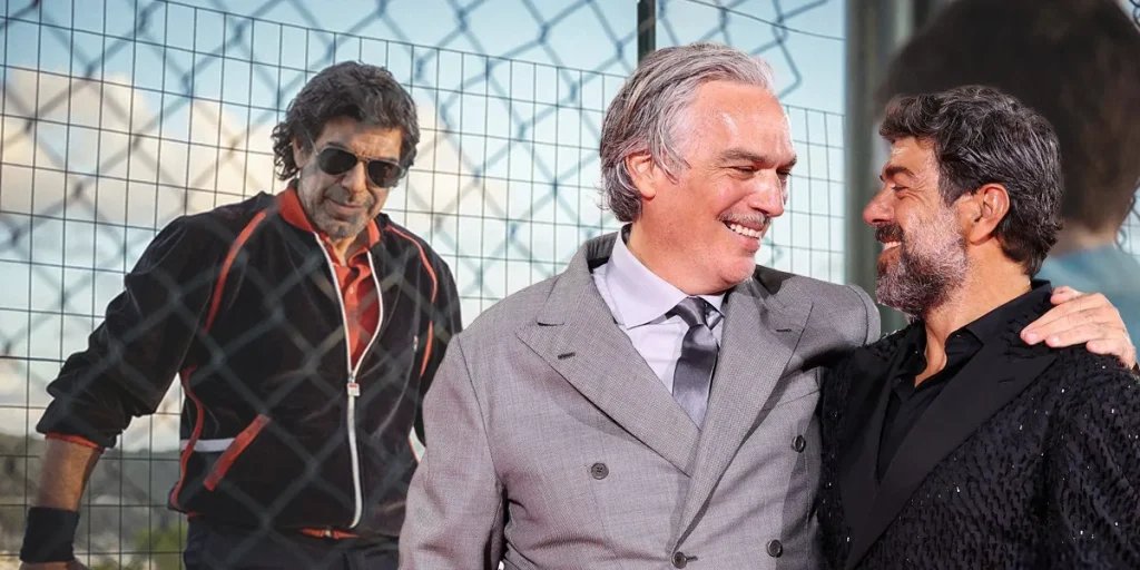 Andrea Di Stefano and Pierfrancesco Favino hug at the Venice Film Festival in front of a photo from Il Maestro (My Tennis Maestro), about which we interview them
