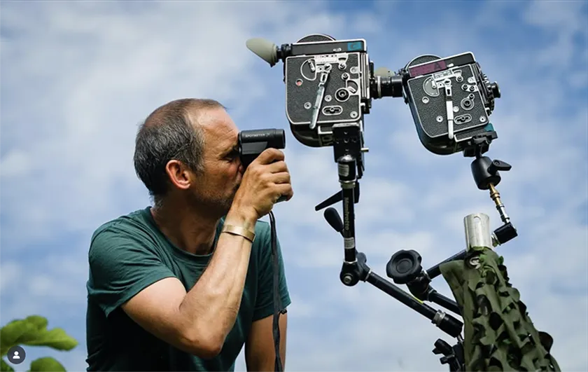Mark Jenkin on the set of Rose of Nevada, preparing to shoot a stunt sequence, in an image featured on a Loud And Clear Reviews interview with the director, Callum Turner and George MacKay