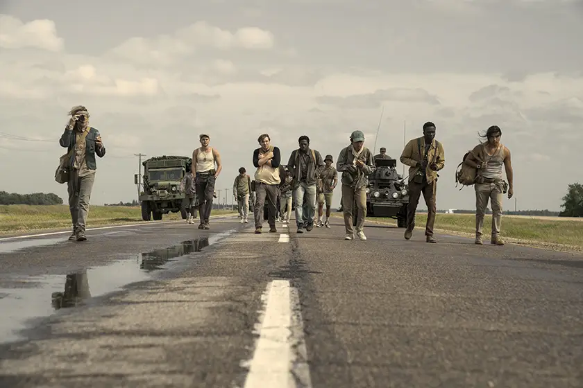 People walk in a street in a still from The Long Walk