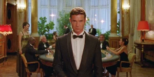 A man wears a suit in a casino in a still from Reflection in a Dead Diamond