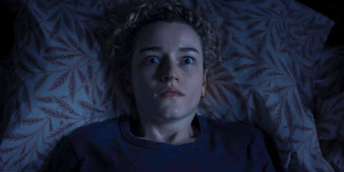 Julia Garner lies in bed wide-eyed in a still from the movie Weapons, one of the best movies of2025 ranked from worst to best by Loud And Clear Reviews