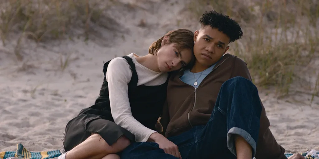 Two teenagers lean on each other on the beach in a still from the movie I Wish You All the Best