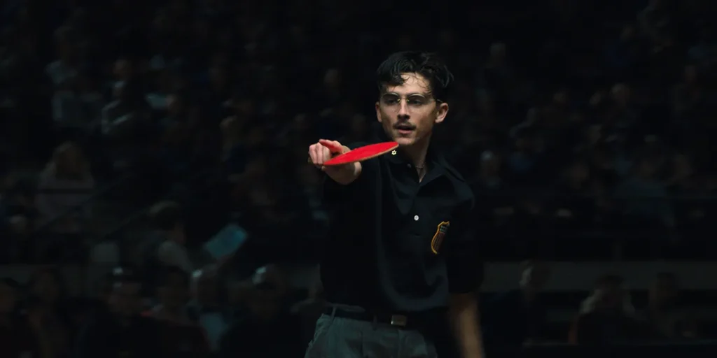 Timothée Chalamet holds a ping pong paddle in Marty Supreme