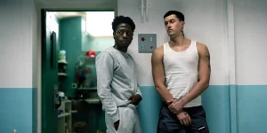 David Jonsson and Tom Blyth lean on a wall in the movie Wasteman