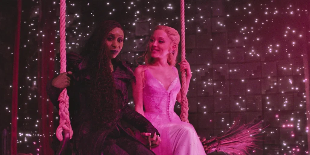 Cynthia Erivo and Ariana Grande sit next to each other as Elphaba and Glinda in WICKED: FOR GOOD