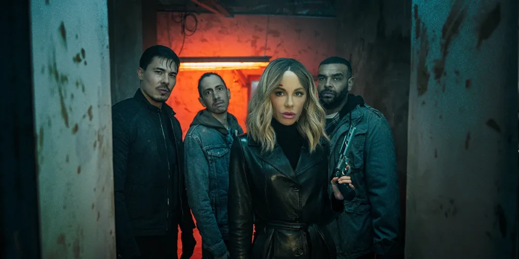 Kate Beckinsale and three men stand in a corridor looking straight into the camera in a still from the 2025 movie "Wildcat"
