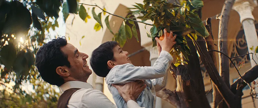 A father and his song pick oranges smiling in a still from All That's Left of You