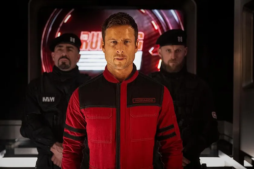 Glen Powell in a still from the new Running Man movie (2025), which is better than the original according to Loud And Clear Reviews