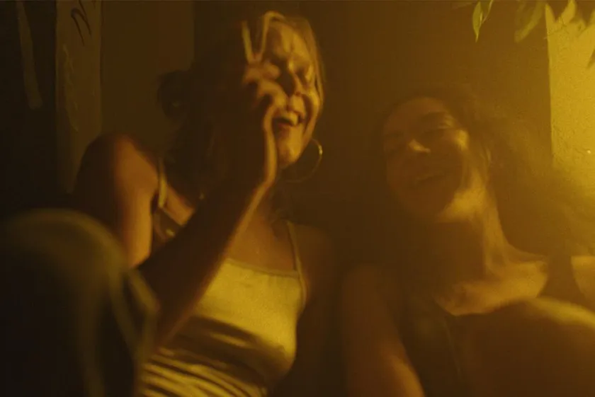 Two girls laugh and smoke in a still from the movie Erupcja, which is part of Charli XCX’s Film Industry Takeover