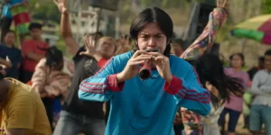 A boy plays an instrument in a still from Levitating