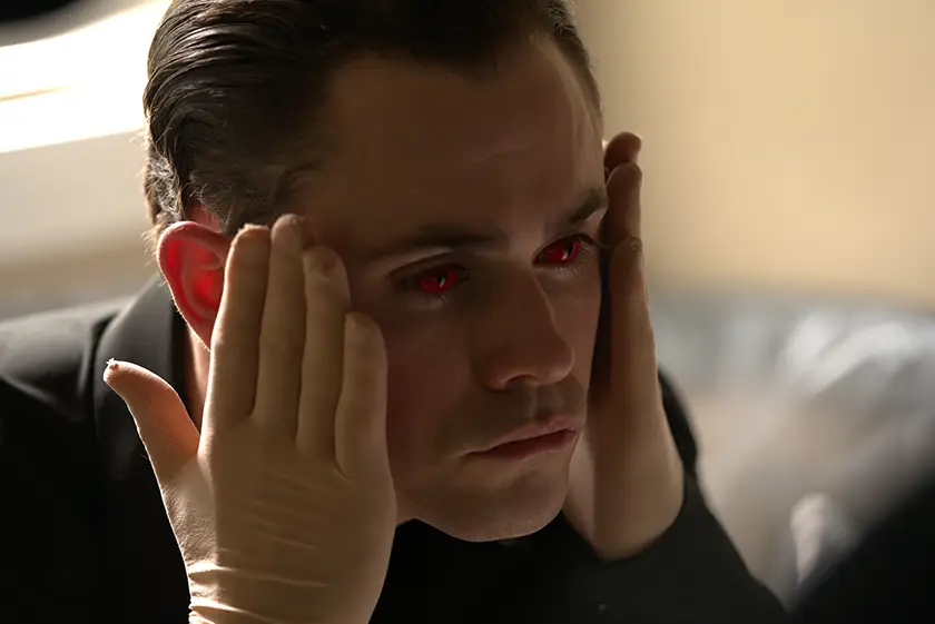 Dacre Montgomery touches his face and has red eyes in Faces of Death (2026)