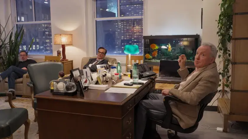 Erik Kenward, Steve Higgins and Lorne Michaels sits at his desk with Erik Kenward and Steve Higgins in a still from the movie Lorne