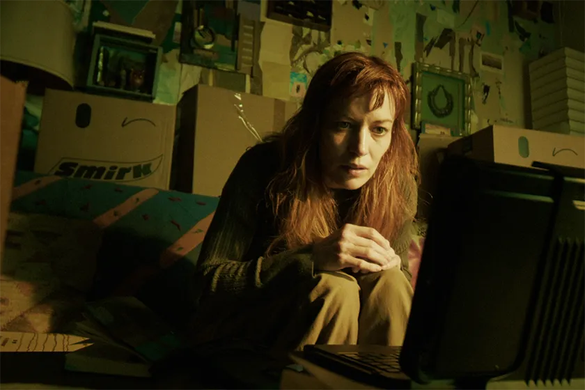 Britt Lower looks at a computer screen with a confused expression in a still from the movie "Sender"
