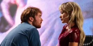 Cooper Hoffman and Olivia Wilde stare at one another in the 2026 movie I Want Your Sex