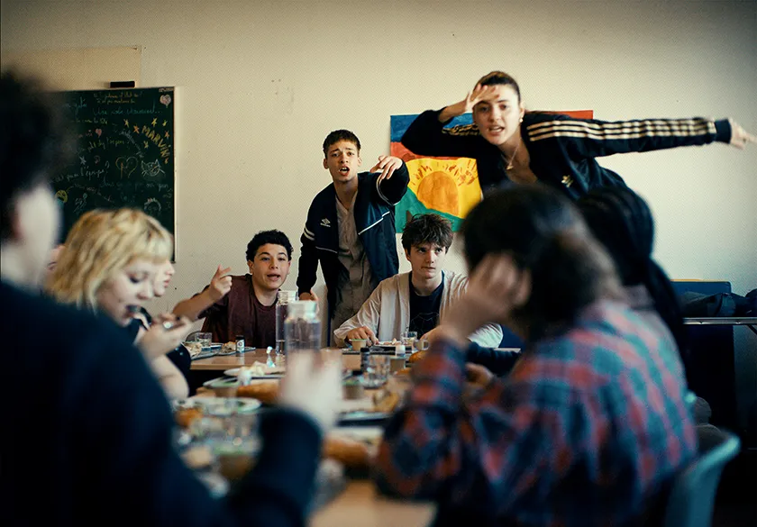 Students sit, eat and talk in a still from 15/18 (A Place to Heal)