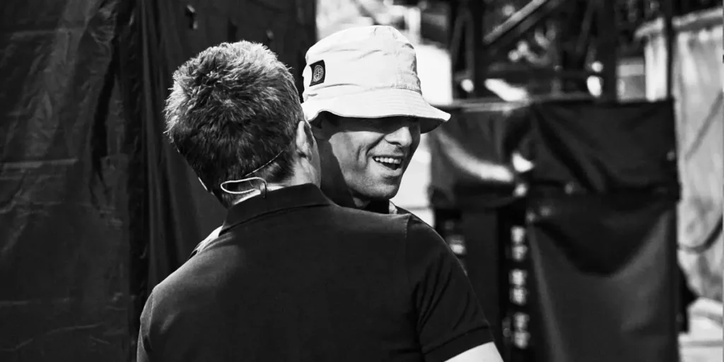 Liam and Neil Gallagher talk to each other in a black and white photo taken behind the scenes at their Wembley concert in 2020, used in the documentary movie Oasis: Don't Look Back in Anger