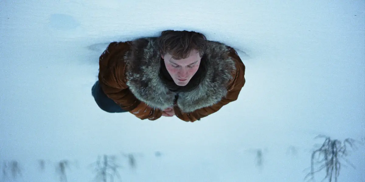 Fred Hechinger lies in the snow in a still from A Long Winter, one of the 30 movies to watch at the 2026 BFI London Film Festival according to Loud and Clear Reviews