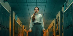 Summer H. Howell stands in a high school corridor in a still from the series Carrie (2026)